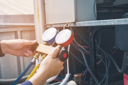 Technician maintaining air conditioner