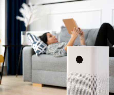 Woman lying on couch with air scrubber nearby