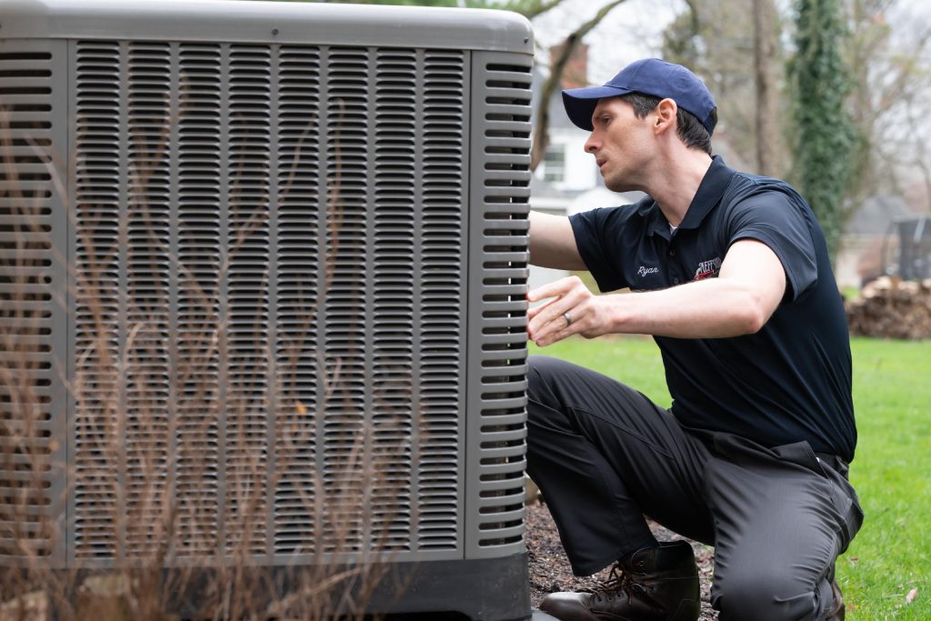 Technician maintaining a home AC unit