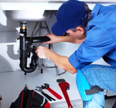 Neffsville employee working on kitchen sink pipes